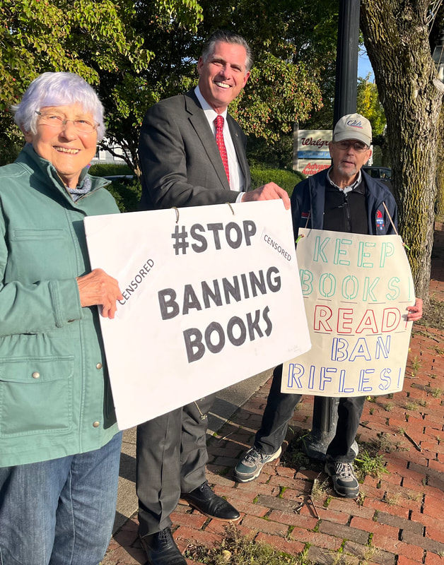 BCCR members and Bridgewater State University President Fred Clark hold signs at 9/26/23 book banning. Signs say, "#Stop book banning," and "Keep books. Read. Ban Rifles!"